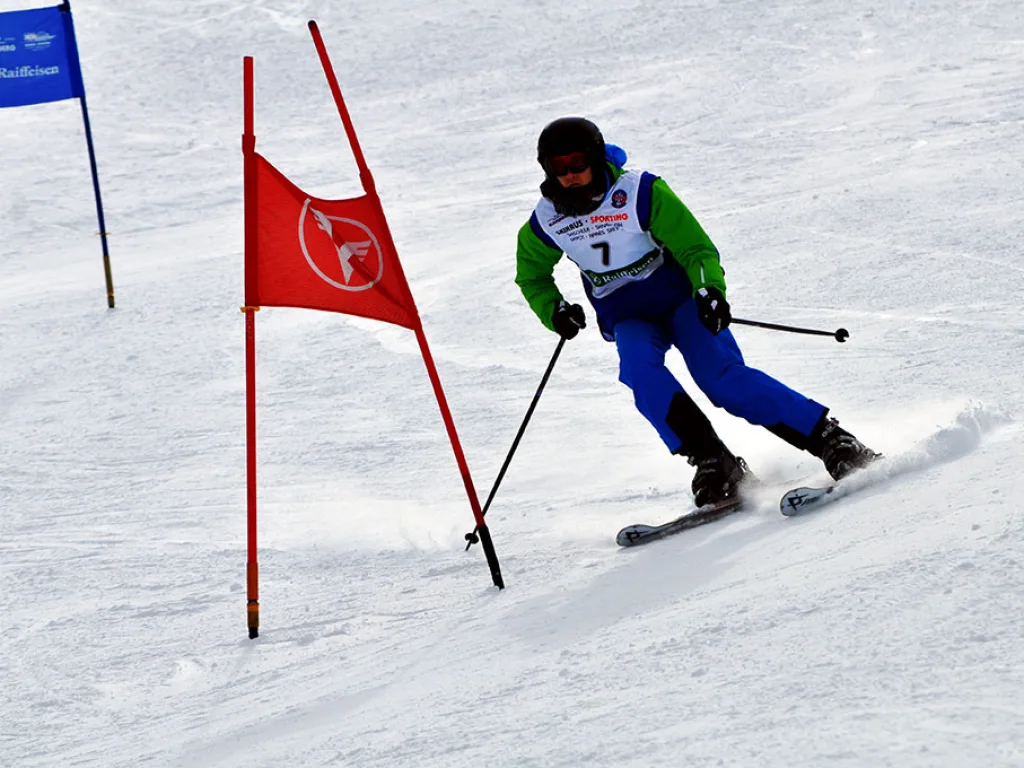 Skifahrer mit Startnummer 7 zieht eine Kurve am Tor.